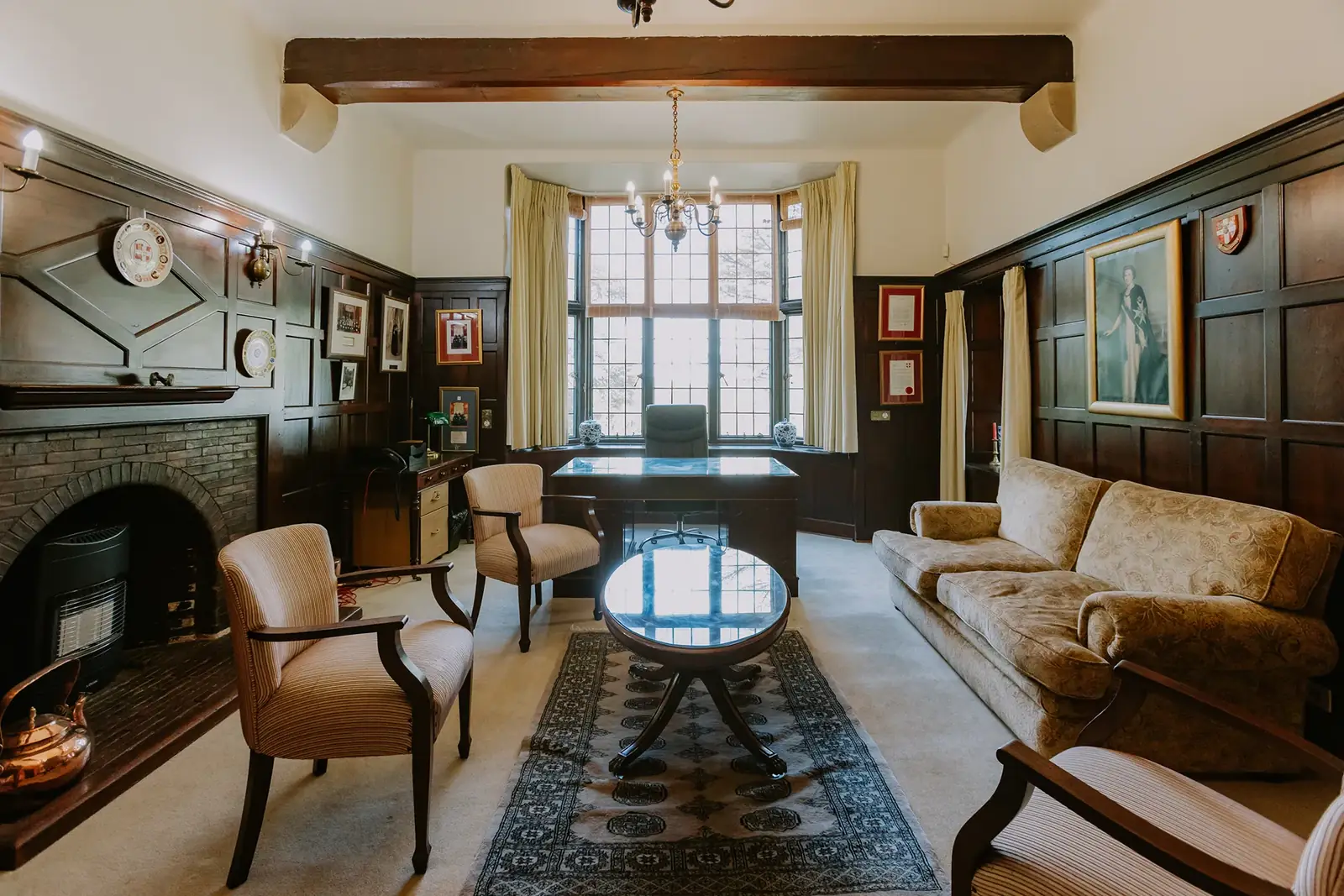 The Executive Suite at Glenshiel, a panelled room with a fireplace and armchairs