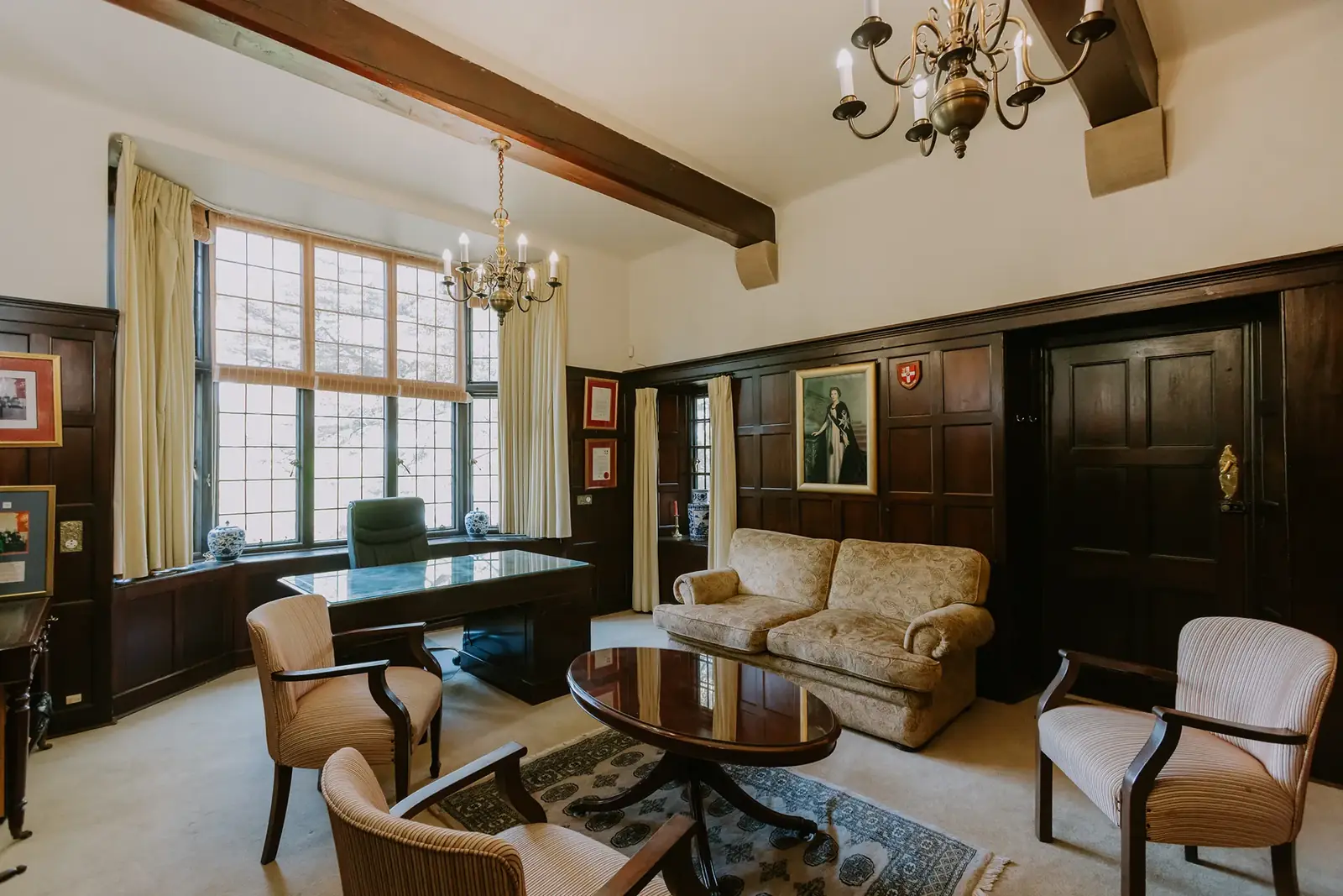 The Executive Suite at Glenshiel, a panelled room with a fireplace and armchairs
