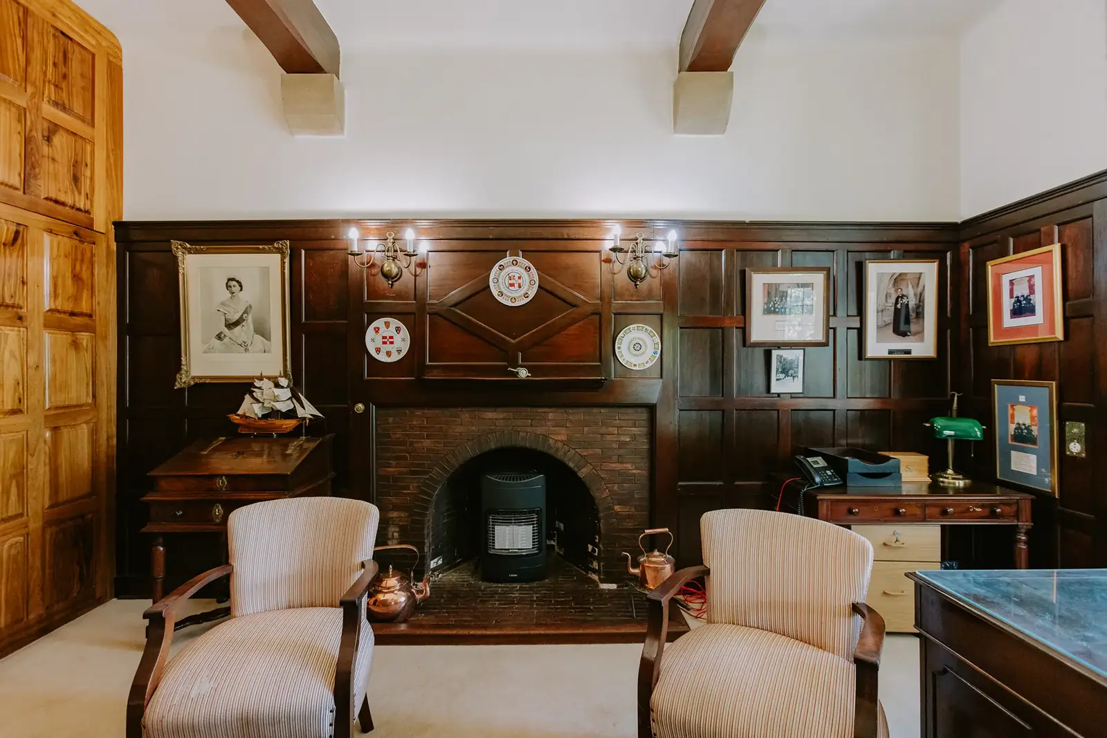 The Executive Suite at Glenshiel, a panelled room with a fireplace and armchairs