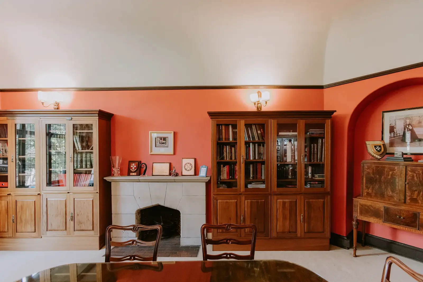 The Library at Glenshiel, lined with bookcases against warm red walls