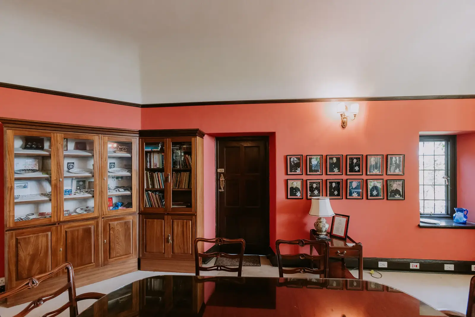 The Library at Glenshiel, lined with bookcases against warm red walls