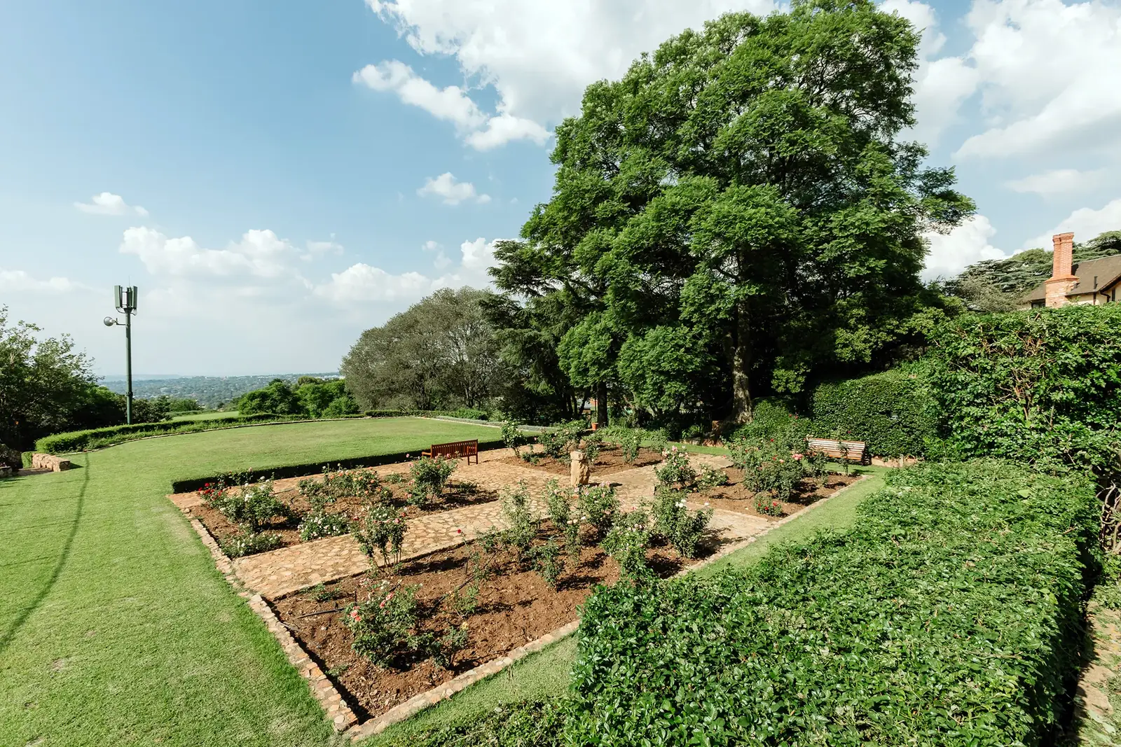 The Rose Garden at Glenshiel, with rose beds, clipped hedges and a stone bench